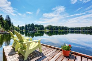 Perfect water view from small pier with two chairs and flowers pot. Waterfront lake with small pier. Northwest, USA